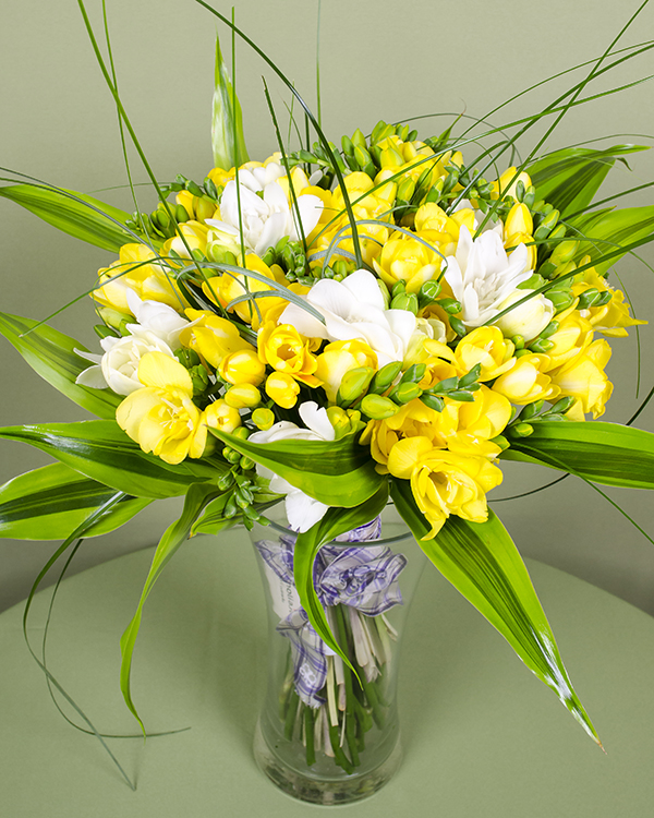 White, yellow freesias bouquet with decorative leaves