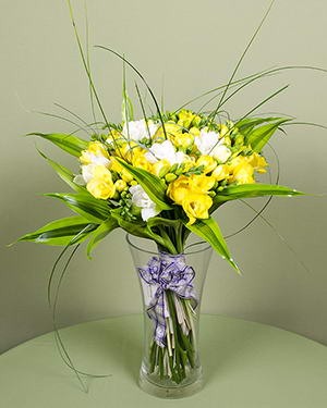 White, yellow freesias bouquet with decorative leaves