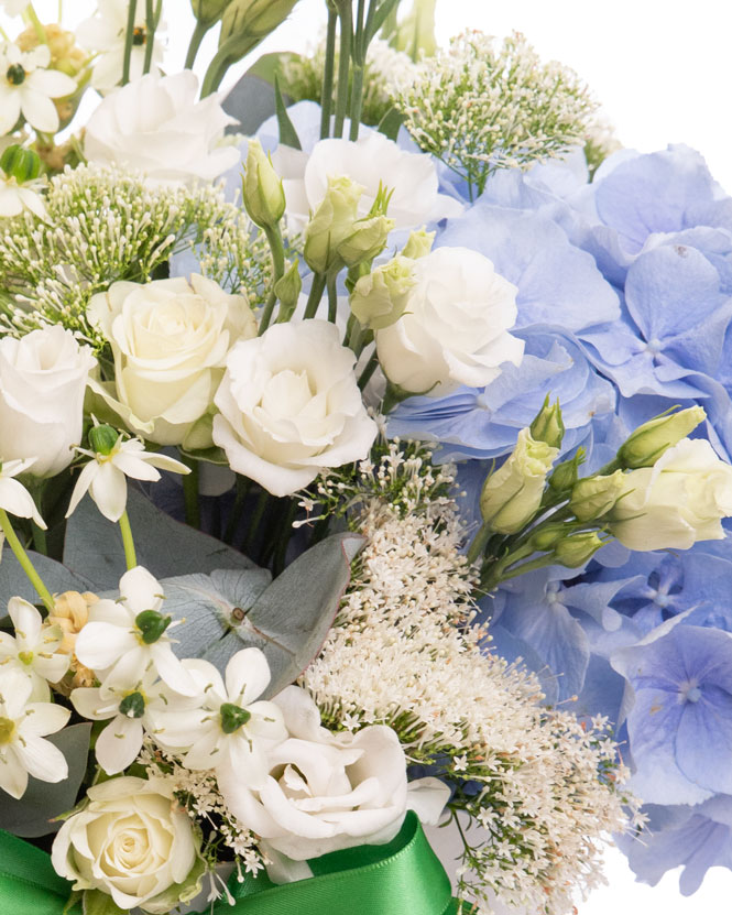 Floral arrangement with white roses and blue hydrangeas