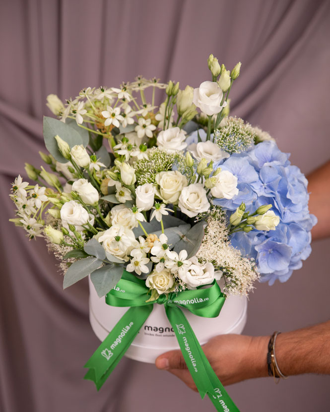 Floral arrangement with white roses and blue hydrangeas